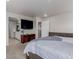 Spacious primary bedroom with a tv, and entry to the ensuite bathroom and walk in closet at 23998 E Atlantic Pl, Aurora, CO 80018