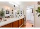 Well-lit bathroom featuring a vanity with wooden cabinets, large mirror, and shower with curtain at 6776 S Ivy St # B5, Centennial, CO 80112
