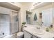 Functional bathroom featuring a glass-enclosed shower, white sink, and ample counter space at 6776 S Ivy St # B5, Centennial, CO 80112