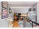 Upstairs hallway with an eclectic gallery wall, hardwood floors and black metal banister at 6776 S Ivy St # B5, Centennial, CO 80112