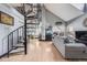 Bright living room with spiral staircase, vaulted ceilings, large windows, and sleek gray sofa at 6776 S Ivy St # B5, Centennial, CO 80112