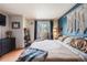 Bright main bedroom with balcony access, decorative wall hanging, hardwood floors, and ample natural light at 6776 S Ivy St # B5, Centennial, CO 80112
