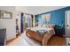 Stylish bedroom with a blue accent wall, balcony access, and decorative macrame wall hanging at 6776 S Ivy St # B5, Centennial, CO 80112