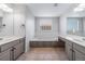 Bright bathroom with double vanities, soaking tub and neutral tile flooring at 18150 Bolero Dr, Parker, CO 80134