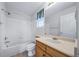 Bright bathroom featuring a bathtub with white tile and a wood vanity at 18150 Bolero Dr, Parker, CO 80134