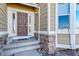 Inviting front entry with a wood door, sidelights, and decorative stone accents at 18150 Bolero Dr, Parker, CO 80134