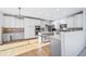 Bright kitchen boasts white cabinets, island, stainless steel appliances, and modern light fixture at 18150 Bolero Dr, Parker, CO 80134