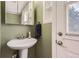 Bathroom featuring a pedestal sink, framed mirror and a white door and trim at 6458 W Clifton Pl, Littleton, CO 80128