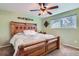 Bedroom with a wooden headboard, window, and ceiling fan offering ample natural light at 6458 W Clifton Pl, Littleton, CO 80128