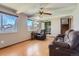 Cozy living room with hardwood floors, large windows, a ceiling fan, and a comfortable seating area at 6458 W Clifton Pl, Littleton, CO 80128