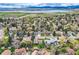 An aerial image of a neighborhood that overlooks a tranquil lake and mountains at 6458 W Clifton Pl, Littleton, CO 80128
