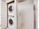 Bathroom features stacked laundry units next to a frosted glass shower, tiled flooring, and a white door at 3252 E 103Rd Dr # 708, Denver, CO 80229
