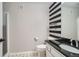 Bathroom featuring black and white striped accent wall, toilet, vanity with black countertop, and tiled flooring at 3252 E 103Rd Dr # 708, Denver, CO 80229