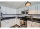 Updated kitchen with stainless appliances, granite countertops, and white cabinets at 3252 E 103Rd Dr # 708, Denver, CO 80229