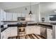 A kitchen area showcasing stainless steel appliances, white cabinets, and contrasting black granite countertops at 3252 E 103Rd Dr # 708, Denver, CO 80229