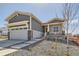 Charming home featuring a two-car garage with stone accents and a welcoming front porch at 423 Basin Daisy St, Castle Rock, CO 80104