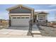 Charming home featuring a two-car garage with stone accents and a welcoming front porch at 423 Basin Daisy St, Castle Rock, CO 80104