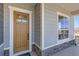 Inviting covered porch with a wood door framed by stone accents and a nearby window at 423 Basin Daisy St, Castle Rock, CO 80104