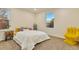 Bright bedroom boasts carpeted floor, two large windows, and unique yellow hand-shaped chair at 8898 Chestnut Hill Ct, Highlands Ranch, CO 80130