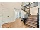 Bright entryway with wood floors, a modern staircase with black railings, and stylish decor at 8898 Chestnut Hill Ct, Highlands Ranch, CO 80130