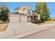 Inviting two-story home with a two-car garage, brick accents, and lush landscaping on a sunny day at 8898 Chestnut Hill Ct, Highlands Ranch, CO 80130