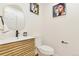 Modern powder room with decorative mirror and artwork, wood vanity, and a sleek, minimalist design at 8898 Chestnut Hill Ct, Highlands Ranch, CO 80130