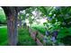Green backyard view with a wooden fence, mature trees, and beautiful purple flowers at 5150 Morning Glory Pl, Highlands Ranch, CO 80130