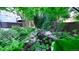 Backyard pond includes lush green foliage, rocks, yellow wildflowers and tranquil water with lily pads at 5150 Morning Glory Pl, Highlands Ranch, CO 80130