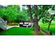 Relaxing outdoor patio with cushioned seating, lush green lawn, and shaded by mature trees at 5150 Morning Glory Pl, Highlands Ranch, CO 80130