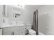 Bright bathroom features a white vanity with drawers, toilet, shower with curtain, and white tiled walls at 5150 Morning Glory Pl, Highlands Ranch, CO 80130