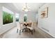 Bright dining area with bay windows, contemporary chandelier, and seating for four; perfect for Gathering meals at 5150 Morning Glory Pl, Highlands Ranch, CO 80130