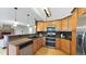 Bright kitchen featuring stainless steel appliances, double oven, and natural wood cabinets and flooring at 5150 Morning Glory Pl, Highlands Ranch, CO 80130