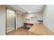 Office space features wood floors, shelving, built-in wood desk, light brown walls, and an entry doorway at 5150 Morning Glory Pl, Highlands Ranch, CO 80130
