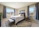 Bright bedroom featuring two large windows, a queen bed, and neutral decor at 2159 Indian Balsam Dr, Monument, CO 80132