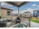 Cozy covered patio with wicker seating, string lights, and views of the fenced backyard and neighborhood at 2159 Indian Balsam Dr, Monument, CO 80132