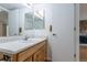 Functional bathroom with a wooden vanity, ample counter space, and a large mirror, offering a practical design at 8463 Everett Way # B, Arvada, CO 80005