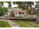 Charming exterior view of a townhouse with a white picket fence and stone chimney, situated in a suburban neighborhood at 8463 Everett Way # B, Arvada, CO 80005