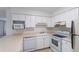 Efficient kitchen featuring white cabinets and appliances, maximizing space and functionality for easy meal preparation at 8463 Everett Way # B, Arvada, CO 80005