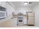 Functional kitchen with white cabinets, white appliances, and ample counter space, ready for culinary adventures at 8463 Everett Way # B, Arvada, CO 80005