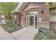 The attractive brick building's front entrance is accessible via a sidewalk lined with mature landscaping at 3872 S Dallas St # 7-304, Aurora, CO 80014