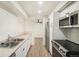 Modern kitchen features stainless steel appliances, white cabinets and light countertops; open to dining area with wood floors at 1113 W 112Th Ave # B, Denver, CO 80234