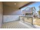 A cozy back porch with wood-style flooring and white brick walls creates an inviting outdoor living space at 6740 Juniper Dr, Thornton, CO 80602