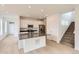 Open-concept kitchen with white cabinets, stainless appliances, and large center island at 6740 Juniper Dr, Thornton, CO 80602