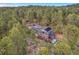 Aerial view of a two-story home with solar panels, a deck, and a hot tub surrounded by tall trees at 4574 Picutis Rd, Indian Hills, CO 80454