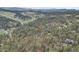 Scenic aerial view of a home surrounded by lush forests and majestic mountains in the distance at 4574 Picutis Rd, Indian Hills, CO 80454