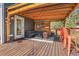 Relaxing covered back deck complete with outdoor furniture and string lights for entertaining at 4574 Picutis Rd, Indian Hills, CO 80454