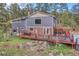Expansive backyard with a deck, patio, hot tub, and lush greenery offers great outdoor space at 4574 Picutis Rd, Indian Hills, CO 80454