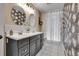 Bathroom featuring dual sinks, decorative mirrors, and a glass-enclosed shower at 4574 Picutis Rd, Indian Hills, CO 80454