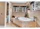 Bright bathroom with a large soaking tub, window, and tiled surround at 4574 Picutis Rd, Indian Hills, CO 80454