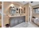 Elegant bathroom features double vanity with grey cabinets, tile floors and decorative accents at 4574 Picutis Rd, Indian Hills, CO 80454